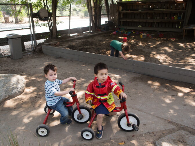 Eric and Sebastian bike in the yard of the Child Educational Center in La Cañada.
