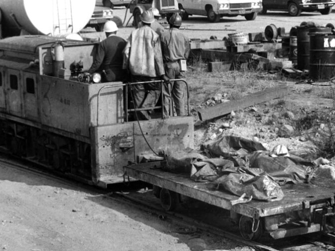Photograph shows rescue workers looking or possible survivors trapped inside the tunnel, but recovering lifeless bodies instead. Here, four Metropolitan Water District Tunnel explosion victims are being brought out. Photograph dated June 26, 1971. 