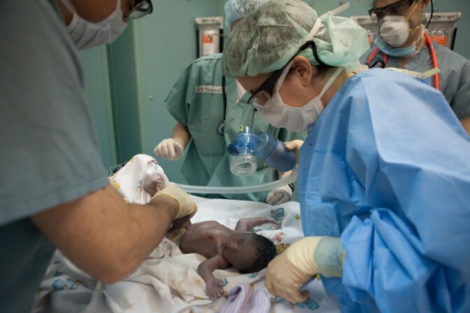 Doctors tend to a newborn baby girl named Esther, delivered by C-section on board the USNS Comfort, a U.S. Naval hospital ship, on January 21, 2010 in Port-au-Prince, Haiti.