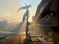 A fireman puts out a fire from homes in the Anaheim Hills neighborhood on October 9, 2017, after the Canyon Fire 2 spread quickly through the area.