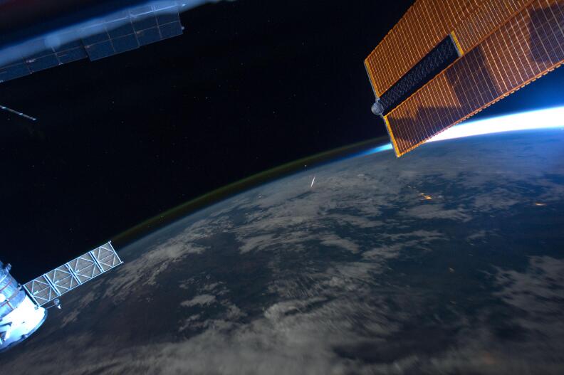 A picture of Earth taken from a spacecraft with a streak of light in the middle.