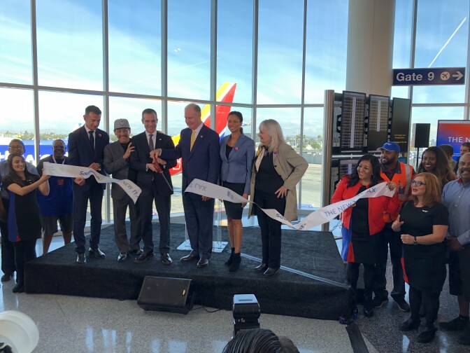 Officials and air travel representatives cut the ribbon on LAX's newly-renovated Terminal 1.