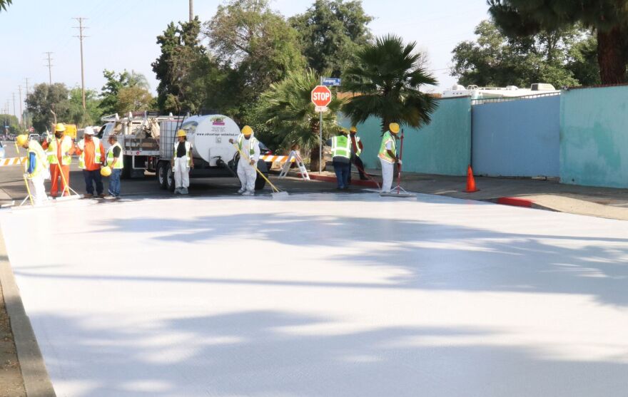 City employees paint a section of Beachy Ave in Pacoima a light gray in May as part of a pilot project to test out "cool pavement."