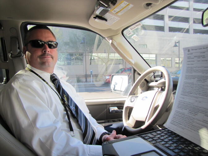 Sgt. Christopher Dowell in his patrol vehicle. The form on the right has all of the information deputies must record after each contact with the public.
