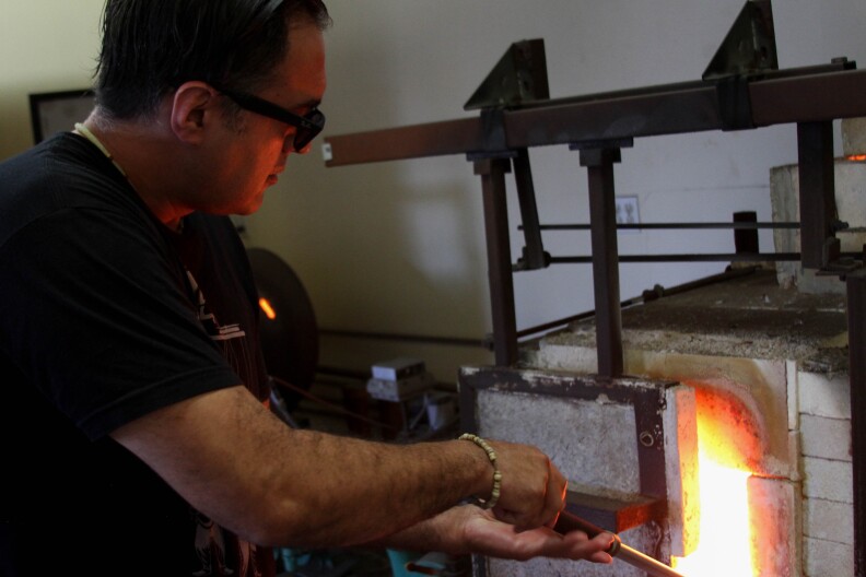 Jaime Guerrero works on a glass cup at the Watts Labor Community Action Committee building in Los Angeles on August 18, 2017.