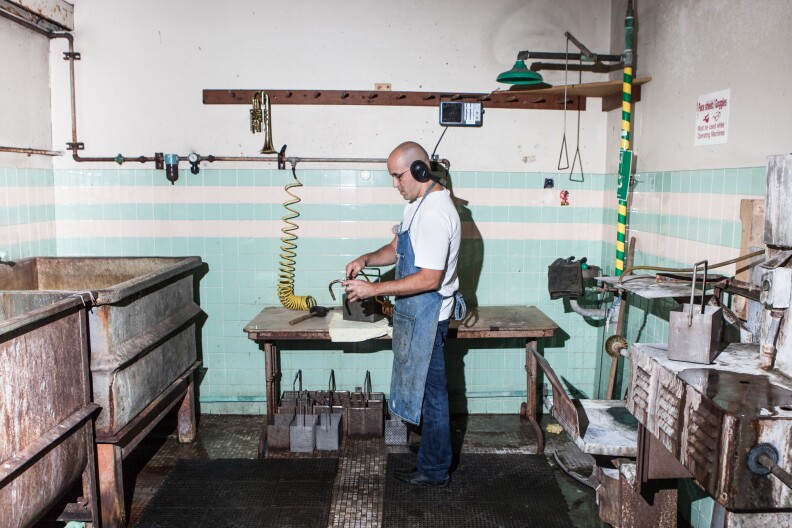 Andrew Palkowitz is one of two brass repair technicians on staff at the Music Repair Shop. He cleans a trumpet after giving it an acid bath in the shop's downtown warehouse.