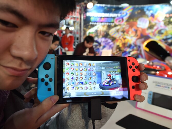 A visitor shows Nintendo's new Switch game console during its game experience session in Tokyo on Jan. 14, 2017.