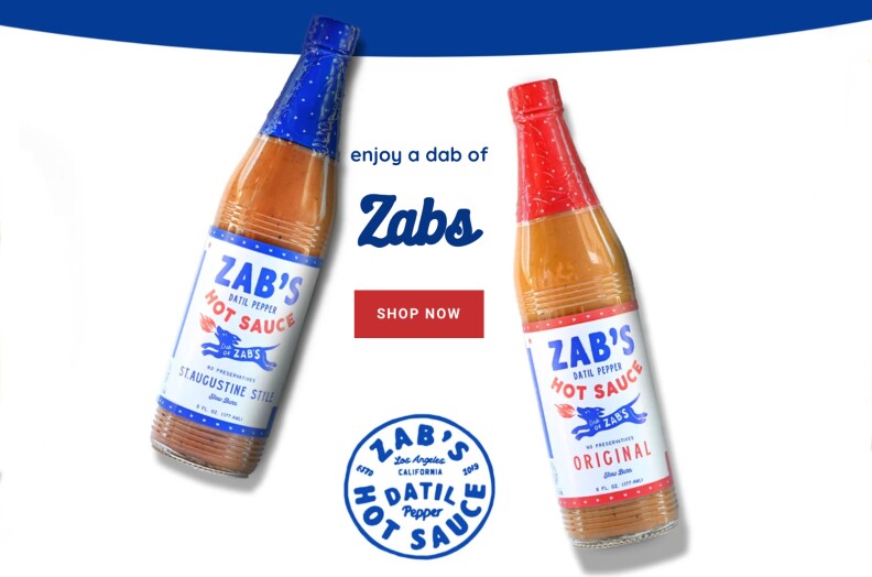 two bottles of Zab's Hot Sauce, one with a blue wrapper and one with a red wrapper, against a white background