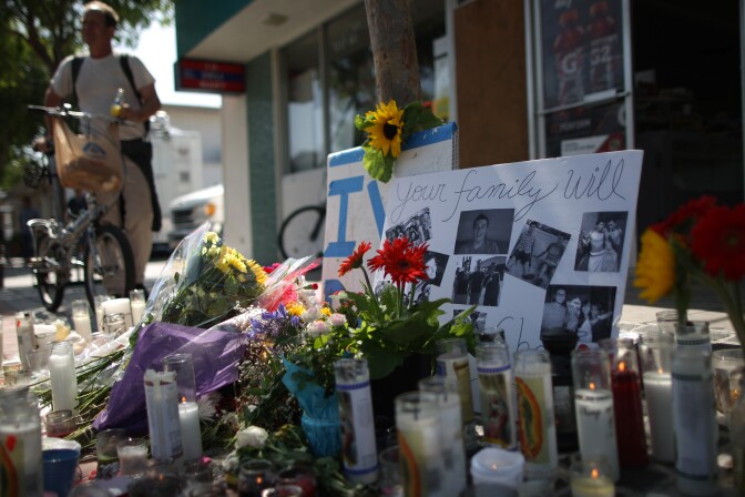 Photos of a victim stand in a makeshift memorial in front of the IV Deli May 25, 2014 in Isla Vista, California. According to reports, 22 year old Elliot Rodger, son of assistant director of the Hunger Games, Elliot Rodger, began his mass killing near the University of California in Santa Babara by stabbing three people to death in an apartment. He then went on to shooting people while driving his BMW and ran down at least one person until crashing with a self-inflicted gunshot wound to the head. Officers found three legally-purchased guns registered to him inside the vehicle. Prior to the murders, Rodger posted YouTube videos declaring his intention to annihilate the girls who rejected him sexually and others in retaliation for his remaining a virgin at age 22. Seven people died, including the Rodger, and seven others wounded, according to authorities.