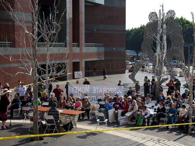 Dozens of Occupy protestors listen to Code Pink co-founder Jodie Evans speak outside of the Edward R. Roybal Federal Building and Courthouse.