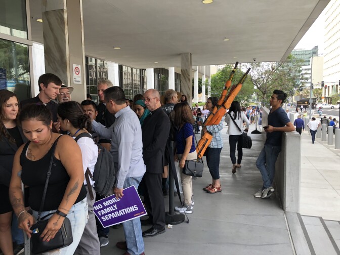 The line of supporters entering the ICE building in support of one young immigrant father facing deportation extends down the block.