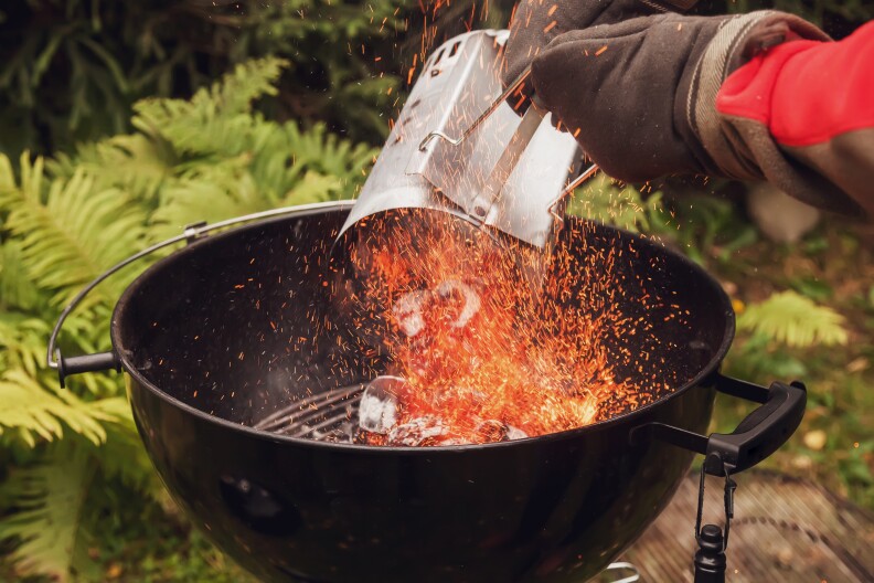 primer plano, de, un, hombre, llevando, guantes, utilizar, un, chimenea, starter, en, un, parrilla barbacoa