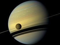 Saturn and Titan as observed by Cassini.
