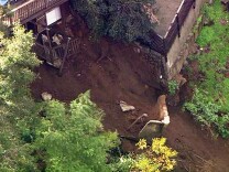 This image made from video provided by KABC-TV shows a slab of concrete that broke away from a home and slid down a rain-soaked hillside in Los Angeles' Hollywood Hills neighborhood Wednesday, Jan. 11, 2016. Some mud and debris fell as far as Laurel Canyon Boulevard below the home, causing the road to be closed. (KABC-TV via AP)