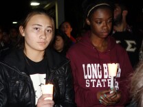 Freshmen Hannah Tsutsui, left, and Jordan Christian hold candles at a vigil for slain student Nohemi Gonzalez, who was killed in the Paris terror attacks Nov 13.