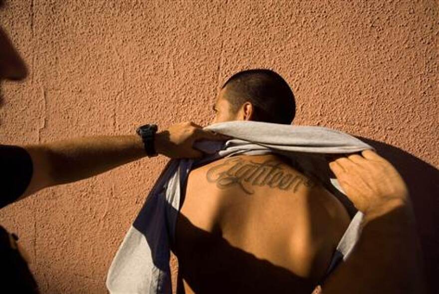 Los Angeles Police Department gang unit officers stop and frisk a known 18th Street gang member in the Rampart district of Los Angeles.