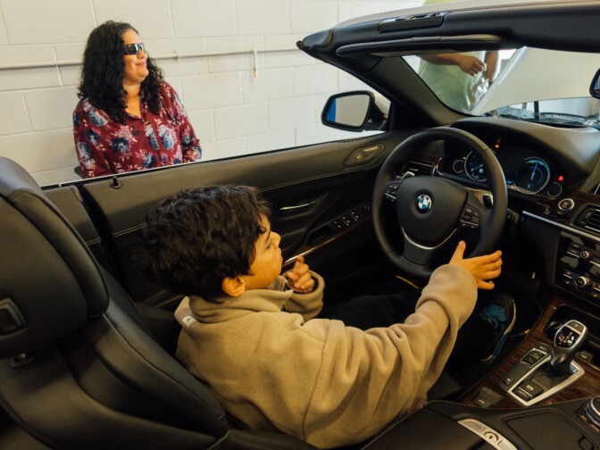 Lizzie Lopez and son check out a car at the opening of the BMW MSTEP at Marine Corps Base Camp Pendleton.