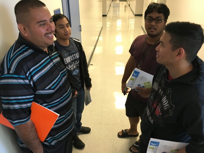 Abraham Hernandez, left, and other former ITT Tech students consider their options at a community college session.