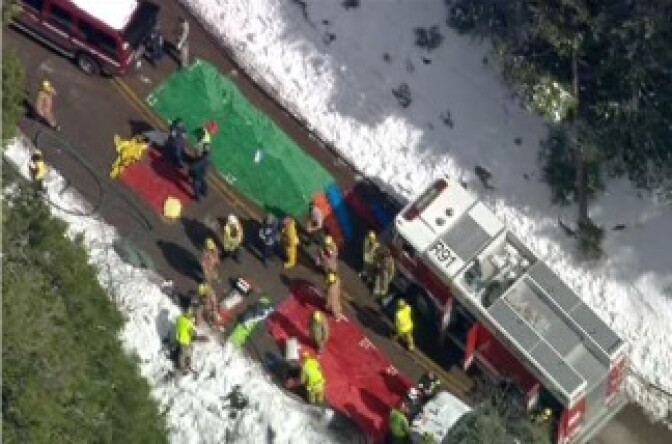 This video image provided by CBS2/KCAL9 News shows rescue efforts after a school bus carrying up to 25 children aboard slid over the side of a highway in a Southern California ski area near Twin Peaks, Calif., after colliding with a Nissan Murano traveling the opposite direction.