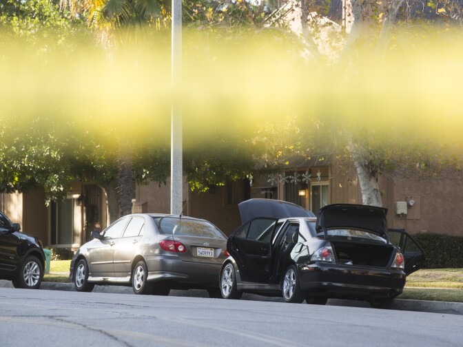 N Center Street between Pine Street and N Center Place remains closed as authorities continue to search a Redlands home on Thursday morning, Dec. 3, 2015 following Wednesday's mass shooting at in San Bernardino. The hood, doors and trunk of a car remain open outside the residence.