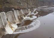 Water and mud cover Pacific Coast Highway north of Deer Creek Road after Sunday's rains forced its closure. 