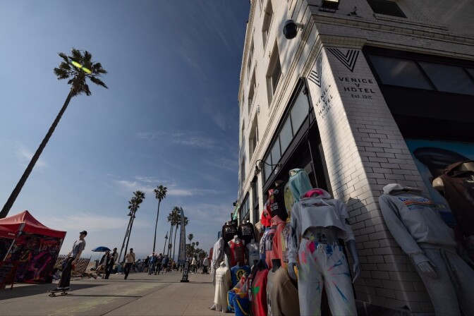 Racks of clothing are displayed outside a building.