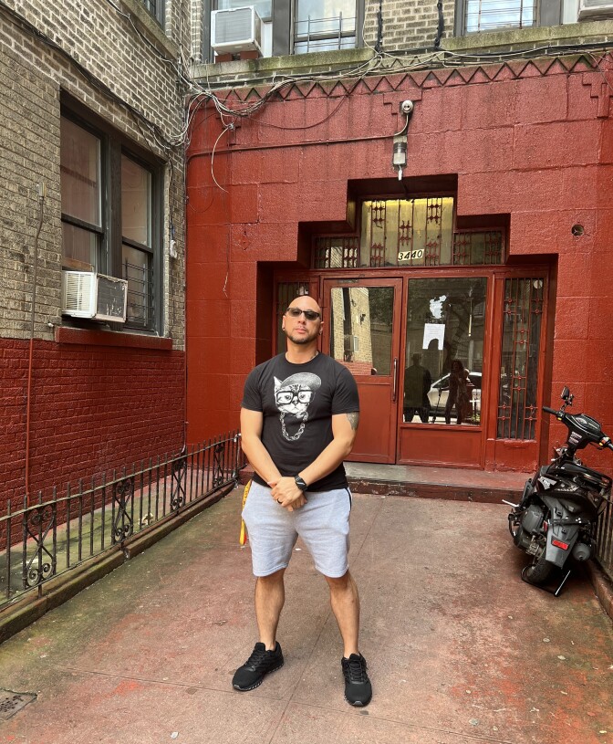 Angel Irizarry outside the last apartment building where his uncle Cesar lived before he died, after speaking with Cesar's former roommate in June 2023.