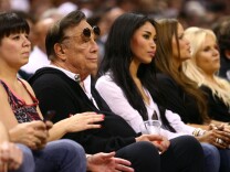 (2nd L) Los Angeles Clippers team owner Donald Sterling with girlfriend V. Stiviano watches the San Antonio Spurs play against the Memphis Grizzlies during Game One of the Western Conference Finals of the 2013 NBA Playoffs at AT&T Center on May 19, 2013 in San Antonio, Texas.