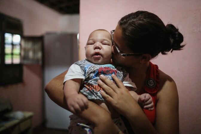 RECIFE, BRAZIL - JANUARY 29:  David Henrique Ferreira, 5 months, who was born with microcephaly, is kissed by his mother Mylene Helena Ferreira on January 29, 2016 in Recife, Pernambuco state, Brazil. In the last four months, authorities have recorded around 4,000 cases in Brazil in which the mosquito-borne Zika virus may have led to microcephaly in infants. The ailment results in an abnormally small head in newborns and is associated with various disorders including decreased brain development. According to the World Health Organization (WHO), the Zika virus outbreak is likely to spread throughout nearly all the Americas.  (Photo by Mario Tama/Getty Images)