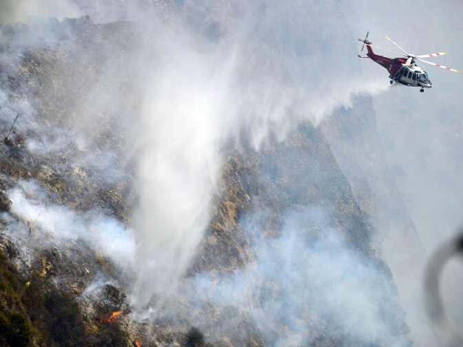 A Los Angeles City Fire Department helicopter makes a water drop on the Brand Fire Sunday afternoon. 