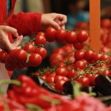 BERLIN, GERMANY - JUNE 21:  A customer buys tomatoes at a fruit and vegetable stand at the Maybachufer market in Kreuzberg district on June 21, 2011 Berlin, Germany. The twice-weekly Maybachufer market is among Berlin's most popular outdoor markets.  (Photo by Sean Gallup/Getty Images)