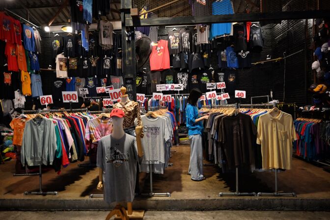 This photo taken on April 16, 2021 shows a lone customer at a T-shirt thrift shop at the Train Night Market Ratchada in Bangkok, as Thailand imposes further restrictions to deal with a spike in the number of Covid-19 coronavirus cases. (Photo by Lillian SUWANRUMPHA / AFP) (Photo by LILLIAN SUWANRUMPHA/AFP via Getty Images)