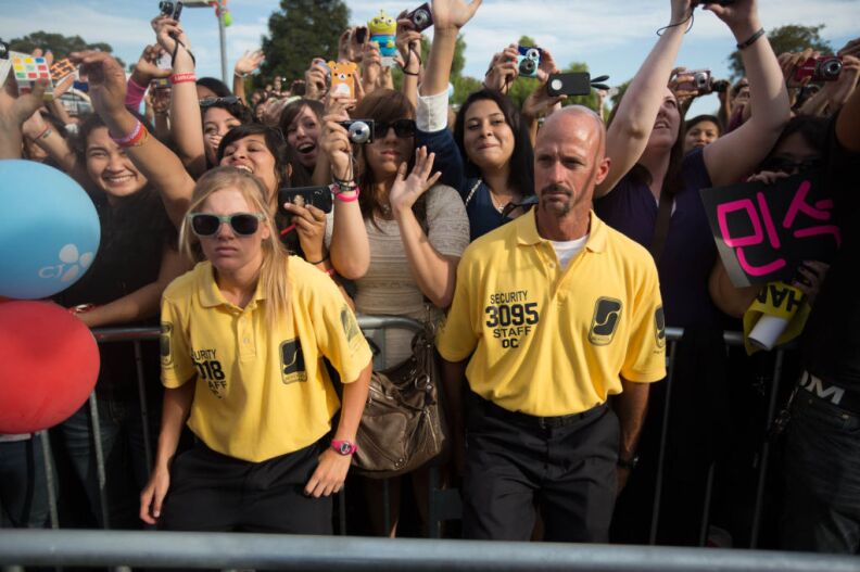Security guards hold back a barrier against surging fans at KCON, the United States' first convention for Korean pop music, at the Verizon Ampitheatre in Irvine, Calif.