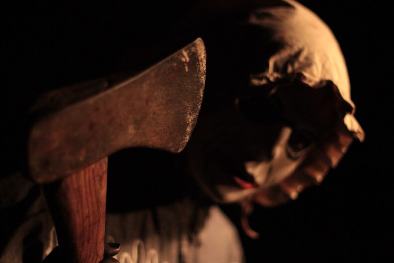 a creepy statue of a woman holding an axe
