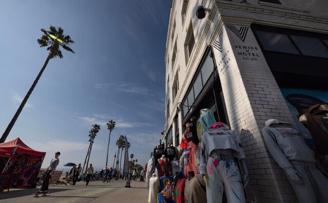 Racks of clothing are displayed outside a building.