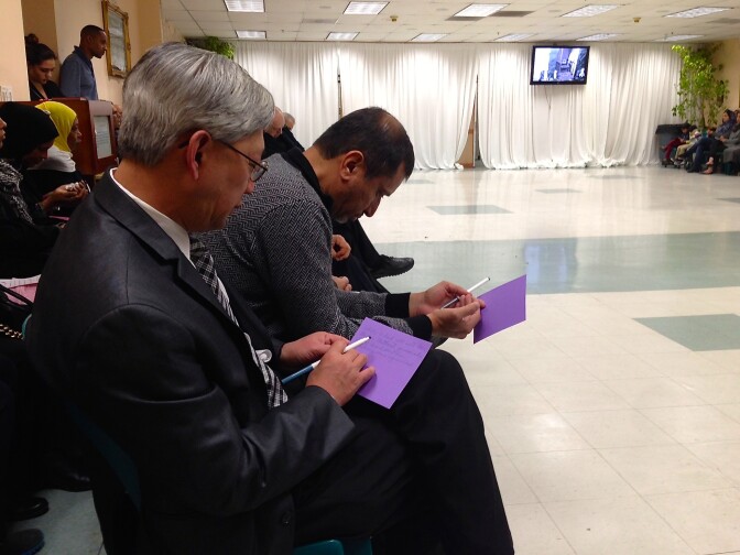 Mourners at the Islamic Center of Southern California write down their remembrances of the late Dr. Maher Hathout.