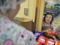 A student talks with cafeteria worker Sophia Villareal as she picks up her breakfast at Brockton Elementary School Monday, June 29, 2012 in Los Angeles.