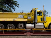 A yellow dump truck on a red platform.