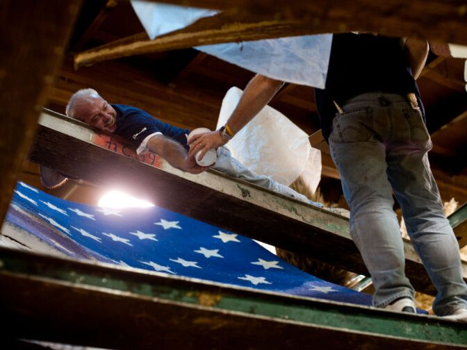 Mark Klemme of Wisconsin, a member of the volunteer organization Kiwanis International, decorates a float from high up. Floats are decorated in locations throughout Pasadena, La Canada Flintridge, Sierra Madre, and Burbank.
