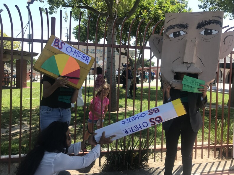 Environmental activists from the East Yards Communities for Environmental Justice pose with signs and protest materials depicting Governor Jerry Brown. 