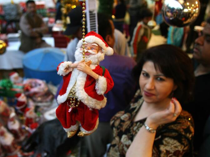 Shoppers look at Christmas items at a store in New Delhi, India on December 24, 2007.