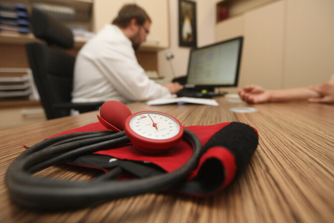 BERLIN, GERMANY - SEPTEMBER 05:  A doctor speaks to a patient as a sphygmomanometer, or blood pressure meter, lies on his desk on September 5, 2012 in Berlin, Germany. Doctors in the country are demanding higher payments from health insurance companies (Krankenkassen). Over 20 doctors' associations are expected to hold a vote this week over possible strikes and temporary closings of their practices if assurances that a requested additional annual increase of 3.5 billion euros (4,390,475,550 USD) in payments are not provided. The Kassenaerztlichen Bundesvereinigung (KBV), the National Association of Statutory Health Insurance Physicians, unexpectedly broke off talks with the health insurance companies on Monday.  (Photo by Adam Berry/Getty Images)