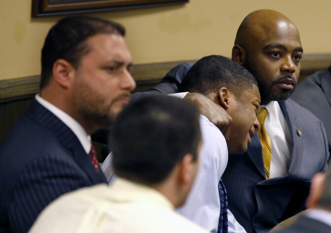 Defense attorney Walter Madison, right, holds his client, 16-year-old Ma'Lik Richmond, second from right, while defense attorney Adam Nemann, left, sits with his client Trent Mays, foreground, 17, as Judge Thomas Lipps pronounces them both delinquent on rape and other charges after their trial in juvenile court in Steubenville, Ohio, Sunday, March 17, 2013. Mays and Richmond were accused of raping a 16-year-old West Virginia girl in August 2012. (AP Photo/Keith Srakocic, Pool)