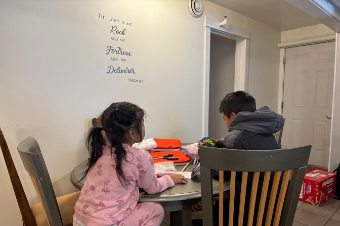 Two children draw in coloring books in a safe house.