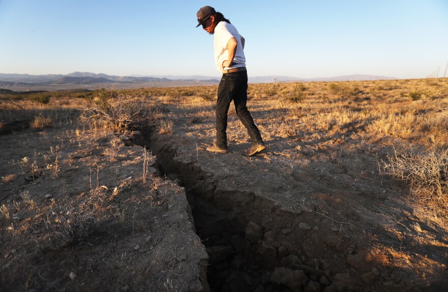 RIDGECREST, CALIFORNIA - JULY 04: A local resident inspects a fissure in the earth after a 6.4 magnitude earthquake struck the area on July 4, 2019 near Ridgecrest, California. The earthquake was the largest to strike Southern California in 20 years with the epicenter located in a remote area of the Mojave Desert. The temblor was felt by residents across much of Southern California. (Photo by Mario Tama/Getty Images)