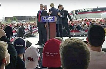 U.S. Secret Service agents surround GOP presidential candidate Donald Trump as other security officers subdue a man who attempted to rush the stage during a Trump rally in Dayton, Ohio, on March 12, 2016.