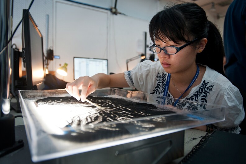 Mandy Zheng, 17, of Davis makes a stop motion animation using black sand. Zheng was inspired by a film called "The ErlKing" she watched at the beginning of the four-week program.