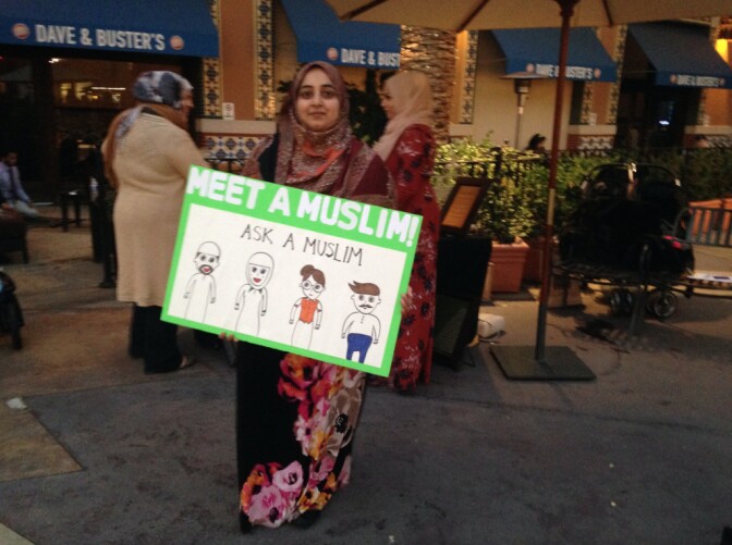Afreen Gaffar holds a sign near the "Meet a Muslim" table at the Irvine Spectrum shopping center last Saturday.