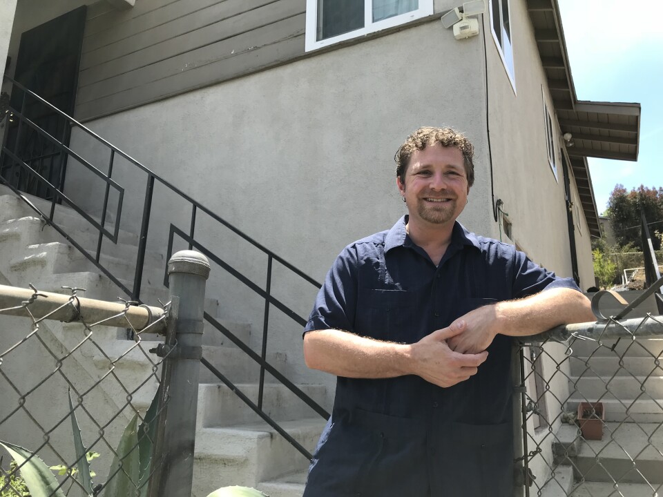 Raphael Leib opens the gate to the City Terrace home he shares with his wife and two young children, July 21, 2018. (David Wagner/KPCC) 