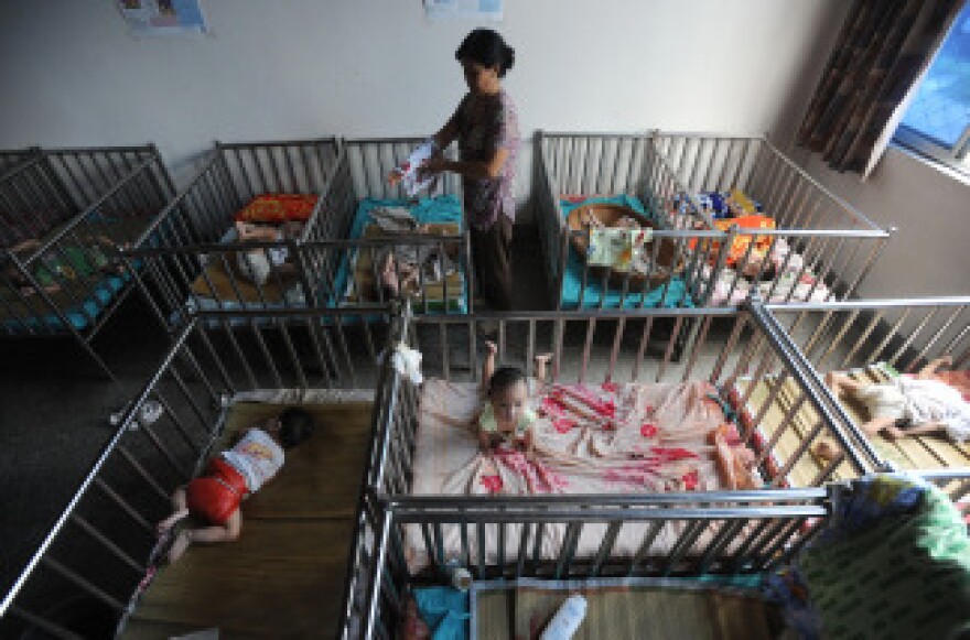 A Chinese worker cares for the babies at an orphanage in Wuhu, in eastern China's Anhui province on August 7, 2009. China has for many years been an attractive place for foreigners looking to adopt children, but the Chinese government has placed restrictions on overseas adoptions in recent years, while encouraging more domestic families to adopt.